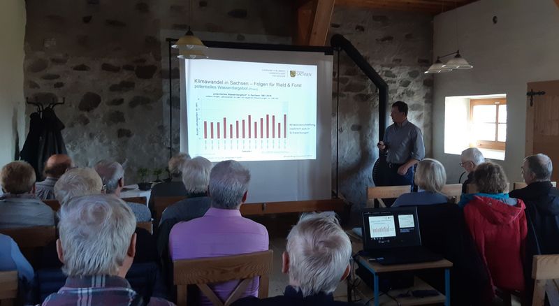 Dr. Johannes Franke zeigt Diagramme zum Klimawandel in Sachsen