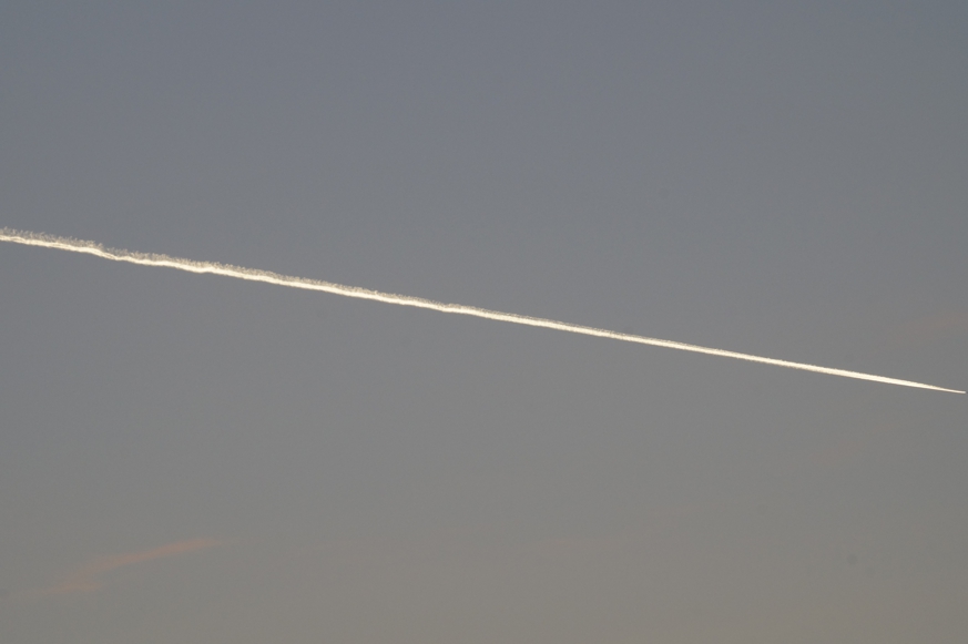 Ein Kondensstreifen zieht diagonal über den Himmel
