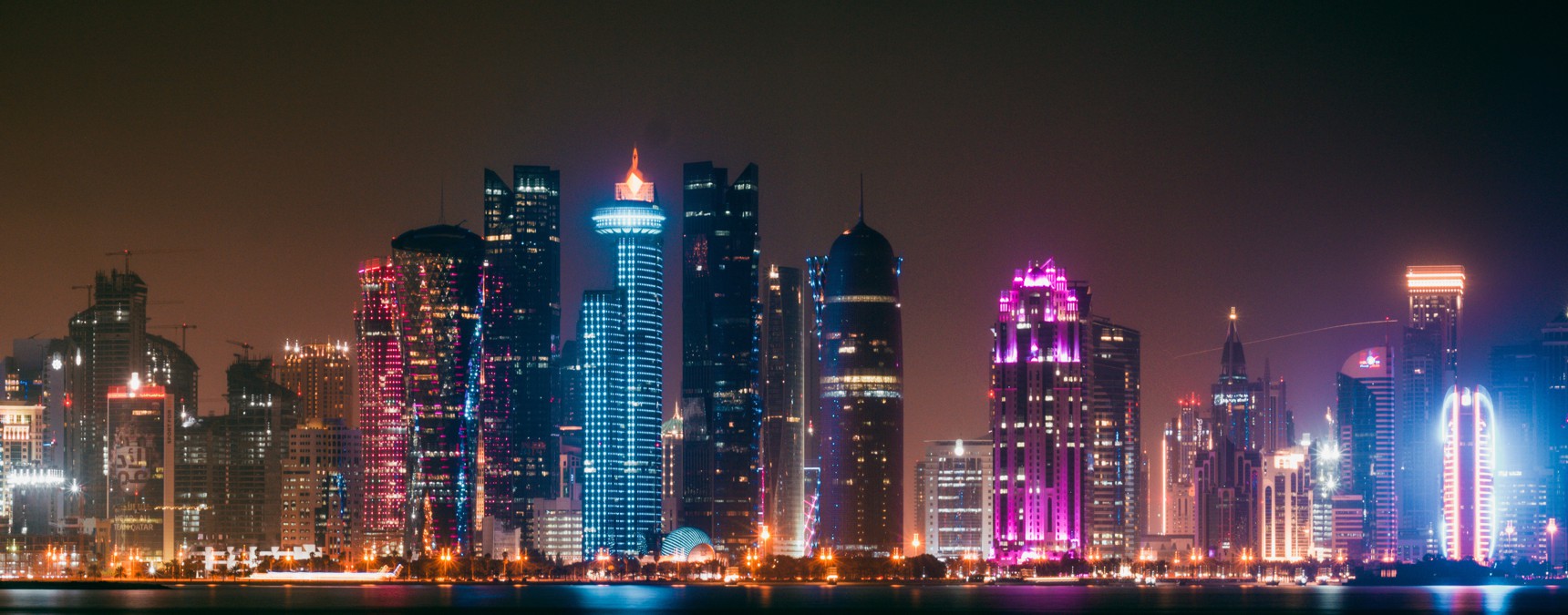 Blick auf  die mit vielen bunten Lichtern illuminierten Hochhäuser einer Stadt 