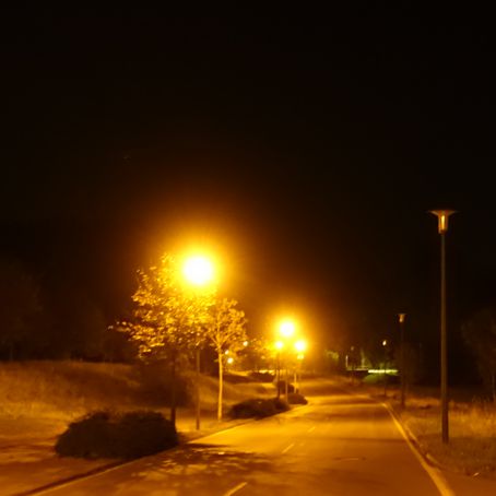 Eine hell erleuchtete, menschenleere Straße im Gewerbegebiet Plauen/Reißig um Mitternacht