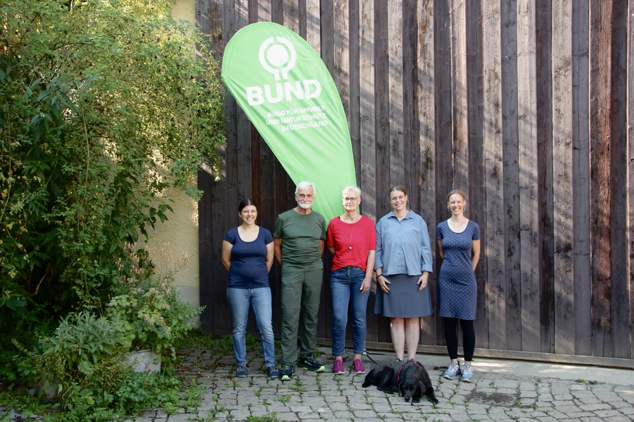 Die Mitglieder des Vorstands vor einer Holzwand und einem BUND Banner
